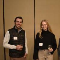 Four alumni smiling together at the event.